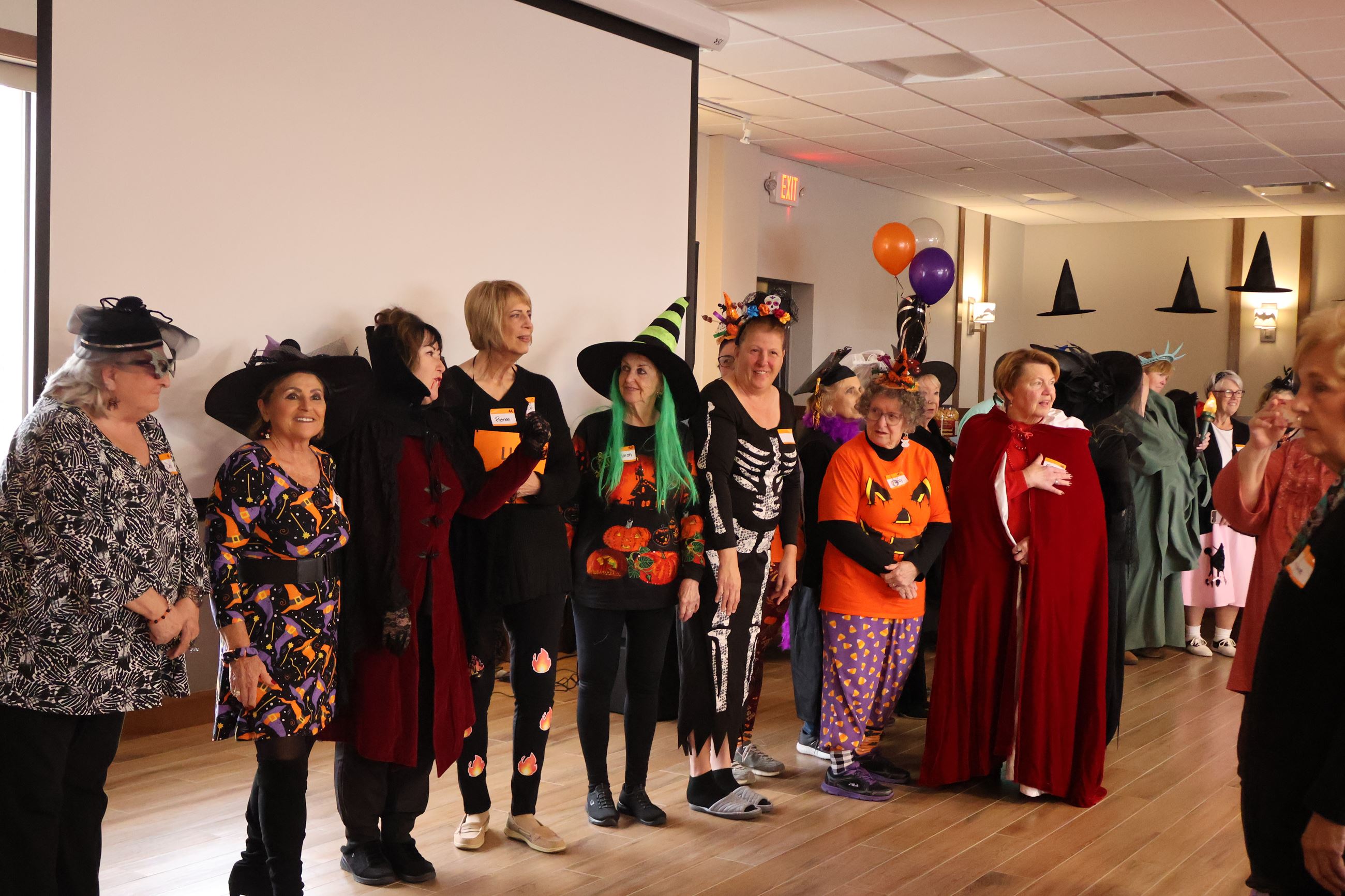 Group of Seniors standing in a line wearing Halloween costumes. 